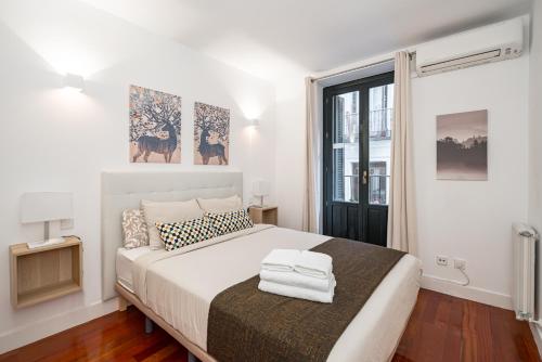 a bedroom with a large white bed and a window at Céntrico Plaza España - Gran Vía II in Madrid