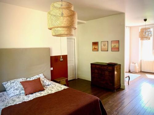 1 dormitorio con 1 cama y suelo de madera en Sous le Tilleul de la Condomine, grand gite piscine privee, en Payrin-Augmontel