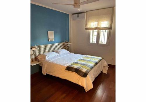 a bedroom with a bed with a blue wall at Apartamento Marion in Cala del Moral