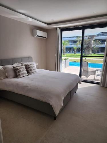 a bedroom with a bed and a view of a pool at Costa Vista- Standard bedroom flat#501 with private pool- kololi sands in Sere Kunda