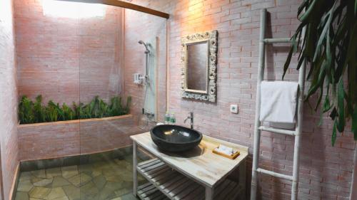 a bathroom with a black sink and a shower at Dusun The Villas in Bawen