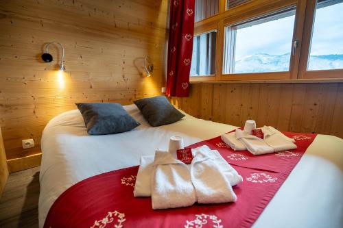 - une chambre avec 2 lits et des serviettes dans l'établissement Village De Vacances Les Flocons Verts, aux Carroz d'Arâches