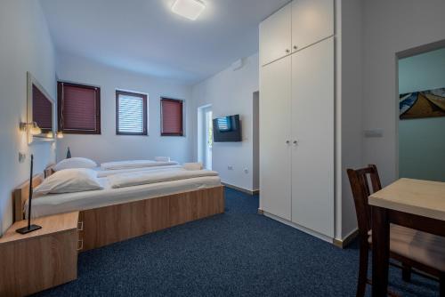 a bedroom with a bed and a desk and a table at Aparthotel Plat in Kožino
