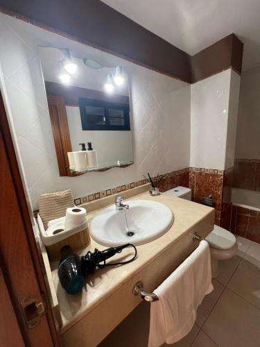 a bathroom with a sink and a mirror and a toilet at Villa Margherita in Playa Blanca