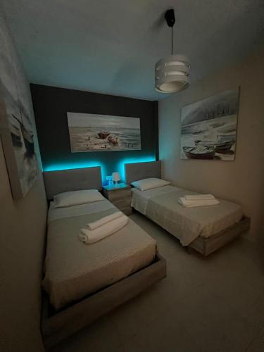 2 letti in una camera con luce blu di Villa Margherita a Playa Blanca