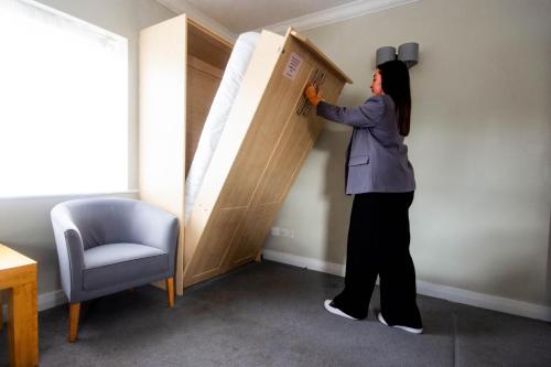 a woman is standing next to a cupboard at The Martello Hotel in Bray