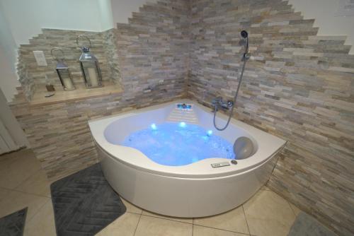 a bath tub with a shower in a bathroom at Pontault-Combault : Ravissante suite avec jacuzzi in Pontault-Combault