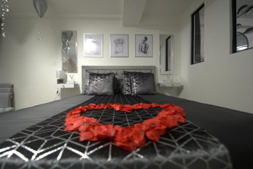 a bedroom with a bed with a red blanket on it at Pontault-Combault : Ravissante suite avec jacuzzi in Pontault-Combault