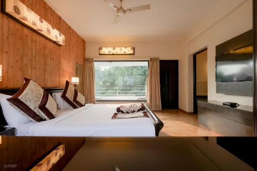 a bedroom with a large bed and a large window at La Sunila Suites & Villas by WSI, Baga in Baga