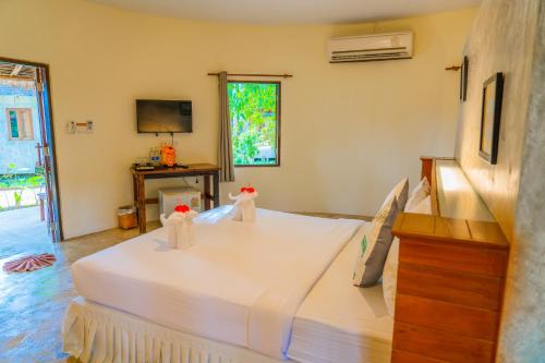 a bedroom with a large white bed with towels on it at The Tropical Beach Resort in Ko Chang