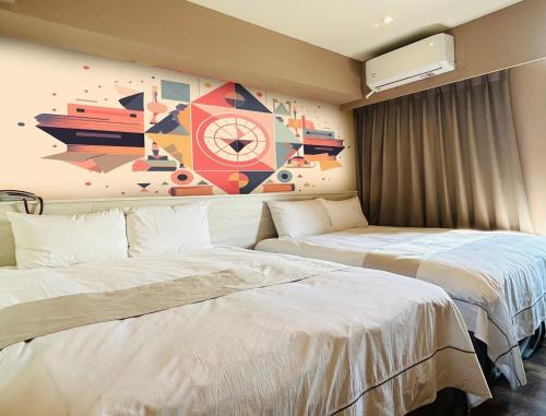 台中的住宿－達斯旅店，酒店客房设有两张床,墙上挂有绘画作品