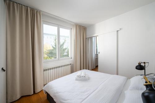 um quarto com uma cama branca e uma janela em Ochota Siewierska Modern Apartment em Varsóvia
