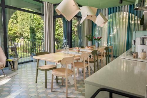 uma sala de jantar com mesa e cadeiras em Bagatelle Gardenhouse em Budapeste