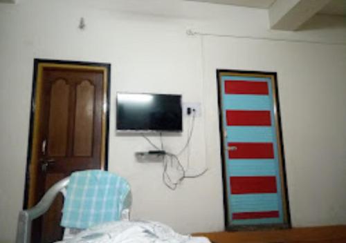 a person in a hospital room with a tv on a wall at Hotel Chanderlok Odisha in Rourkela