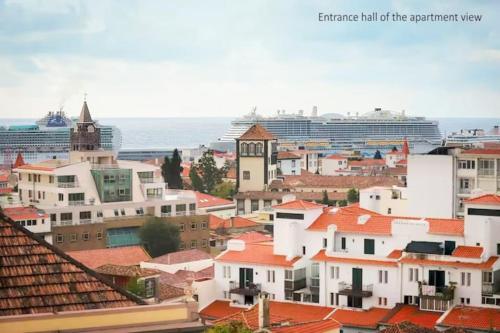 uma cidade com edifícios e um navio de cruzeiro ao fundo em Funchal downtown 5min Marina + 2 bedroom + parking no Funchal