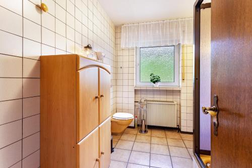 a bathroom with a toilet and a window at Haus Anna in Kirchhundem