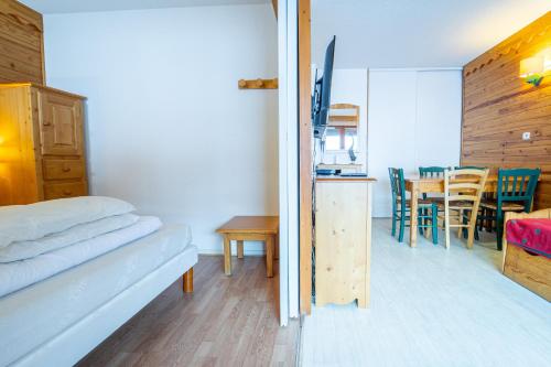 Habitación con cama y mesa con sillas. en Sfl 1 appt 4-6 couchages, en Saint-François-Longchamp