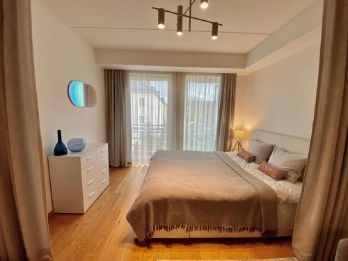 een slaapkamer met een bed, een ladekast en een raam bij Cozy Home Apartment - Tallinn City Center in Tallinn