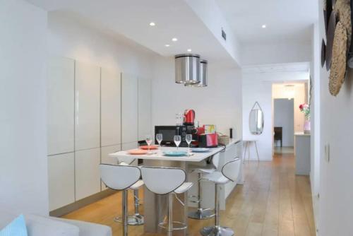 une cuisine avec une table et quatre tabourets dans l'établissement Appartement Centre-ville spacieux, élégant / Climatisation, à Montpellier