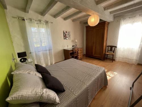 une chambre avec un lit et une grande fenêtre dans l'établissement Moura, à Labastide-Villefranche