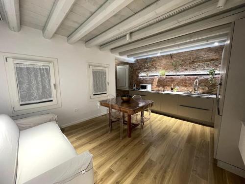 a room with a kitchen and a table in a room at Antico Rudere Luxury Apartment in Chioggia
