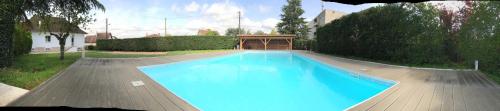 una gran piscina azul en un patio en Villa Lysa, Piscine privee, Coeur de ville, en Figeac