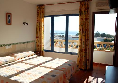 a bedroom with a bed and a large window at Hostal El Dorado in San José