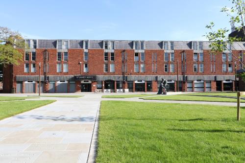 a large red brick building with a green lawn at St James Hotel in Grimsby