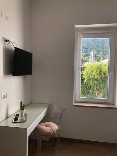 a white room with a desk and a window at Hotel Porta Rivera in LʼAquila