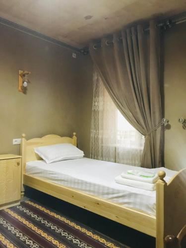 a bedroom with a bed and a window at YAKKA MINOR in Samarkand
