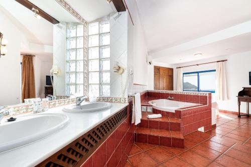 a bathroom with two sinks and a large window at Hostal El Dorado in San José