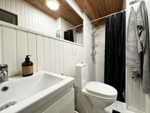 a white bathroom with a sink and a toilet at Cozy little cottage in the middle of Gotland near Visby in Visby