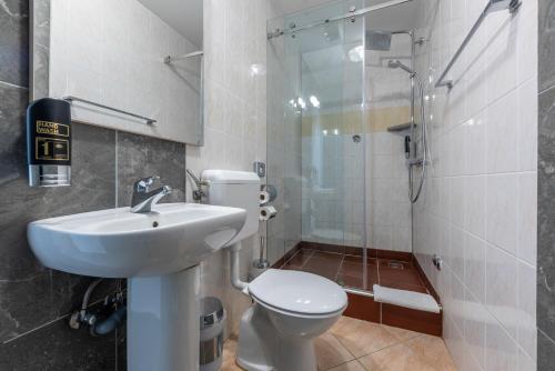 a bathroom with a toilet and a sink and a shower at Aparthotel Plat in Kožino