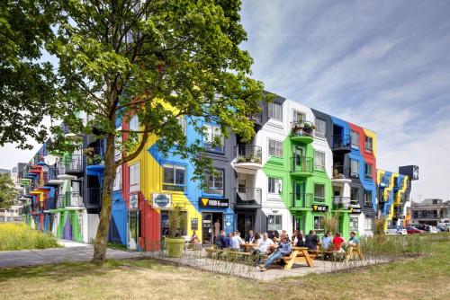 a group of people sitting in front of a colorful building at Apartment Hotel Zuid Oost Heesterveld BnB ZOH in Amsterdam