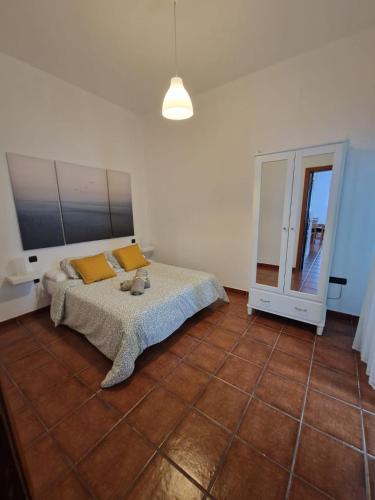 1 dormitorio con cama con almohadas amarillas y espejo en Casa Calandrilla, en Caleta de Caballo