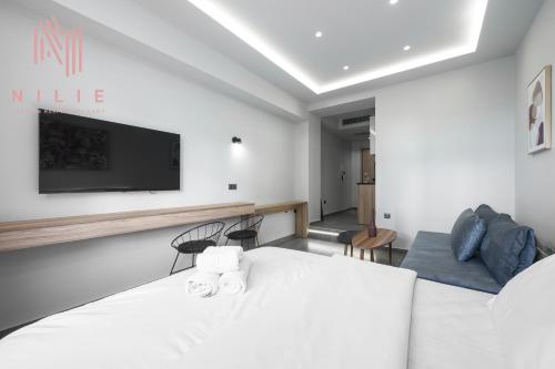 a bedroom with a white bed and a tv on the wall at Pantheon, Nilie Hospitality MGMT in Thessaloniki