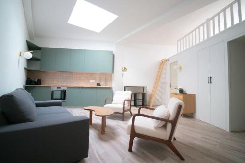 un salon avec un canapé et des chaises et une cuisine dans l'établissement Séjournez dans un havre de paix au cœur de Paris, à Paris