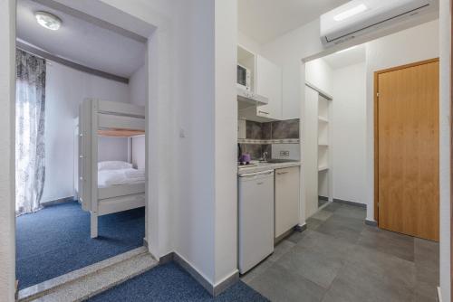 a small room with a bunk bed and a kitchen at Aparthotel Plat in Kožino
