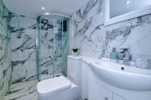 e bagno con servizi igienici, lavandino e doccia. di Finest Retreats - Abbey Road House a Llandudno