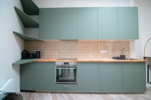 une cuisine avec des armoires bleues et un comptoir dans l'établissement Séjournez dans un havre de paix au cœur de Paris, à Paris