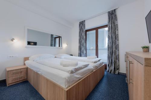 a bedroom with a large bed and a large window at Aparthotel Plat in Kožino