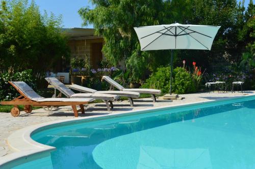 a swimming pool with chairs and an umbrella and a table and chairs at Palazzo Vecchio in Marittima