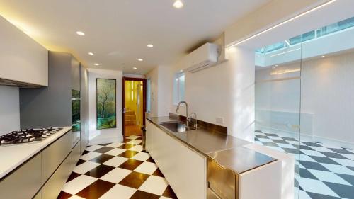 a kitchen with a black and white checkered floor at The Harrington - Knightsbridge - 18 Rutland Gate in London