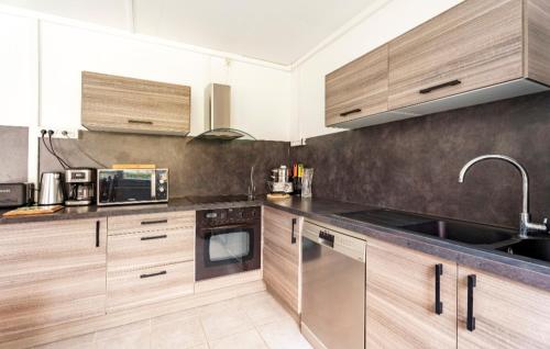 une cuisine avec des armoires en bois et des appareils en acier inoxydable dans l'établissement Familial avec jardin privé, à Allevard