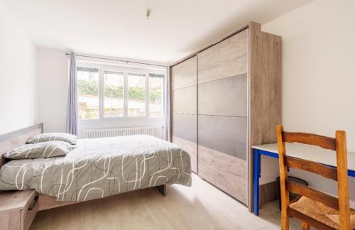 une chambre avec un lit, un bureau et une fenêtre dans l'établissement Familial avec jardin privé, à Allevard