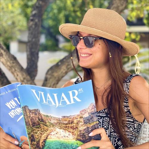 a woman wearing a hat holding a vacation book at Villa Incanto Pina - Torre Canne in Torre Canne