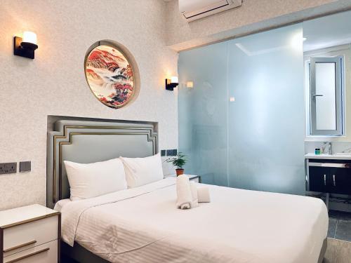 ein Schlafzimmer mit einem großen weißen Bett und einem Spiegel in der Unterkunft Kam Leng Hotel in Singapur