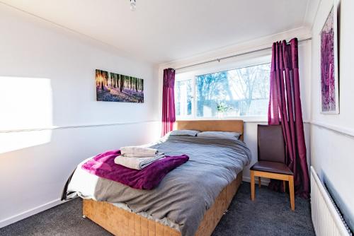 a bedroom with a bed and a window at Redcroft Green - Modern 3 bedroom house in Kenton