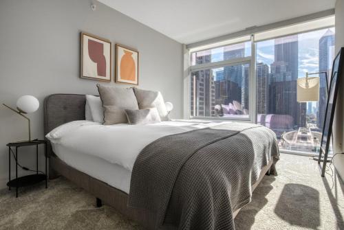 a bedroom with a large bed and a large window at Streeterville 1br w terrace gym nr riverwalk CHI-997 in Chicago