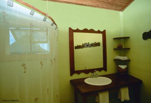 y baño con lavabo, espejo y ducha. en Punta Caracol Acqua Lodge, en Bocas Town